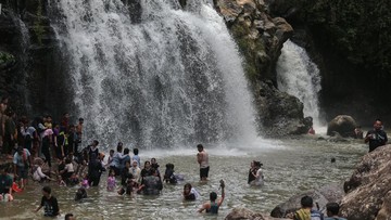 Wisatawan bermain air di sekitar air terjun di Pesona Curug Goong, Mandalawangi, Pandeglang, Banten. Foto: ANTARA FOTO/Angga Budhiyanto